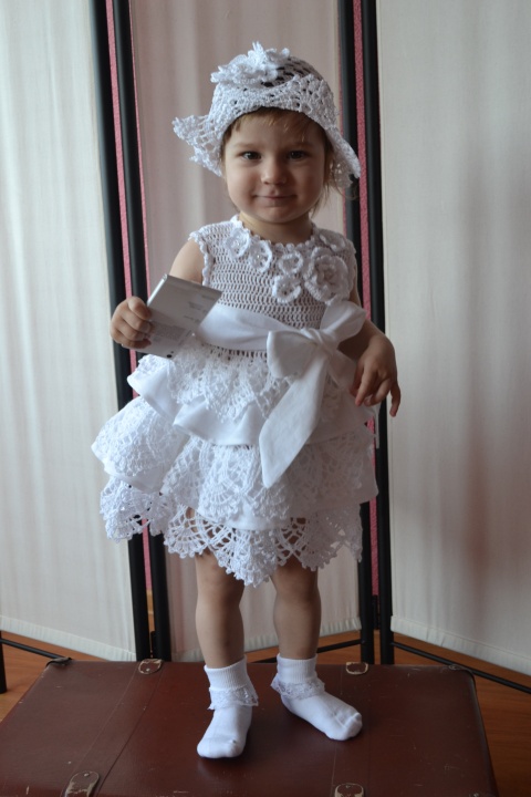 in baptism dress with cap