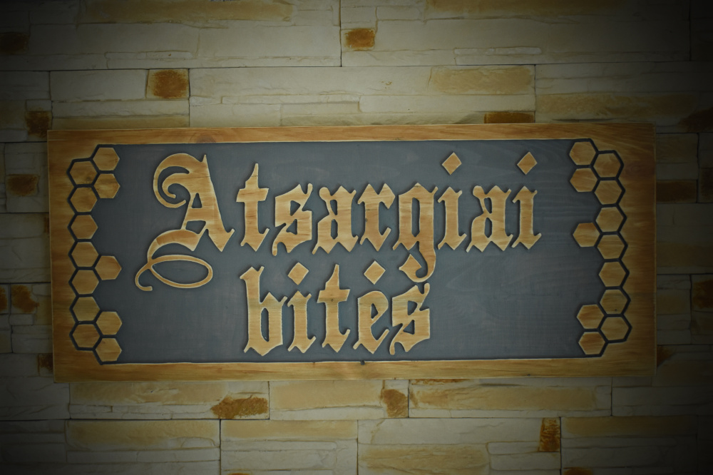 Wooden, handmade signboard "Atsargiai bitės" ("Be careful bees"). 