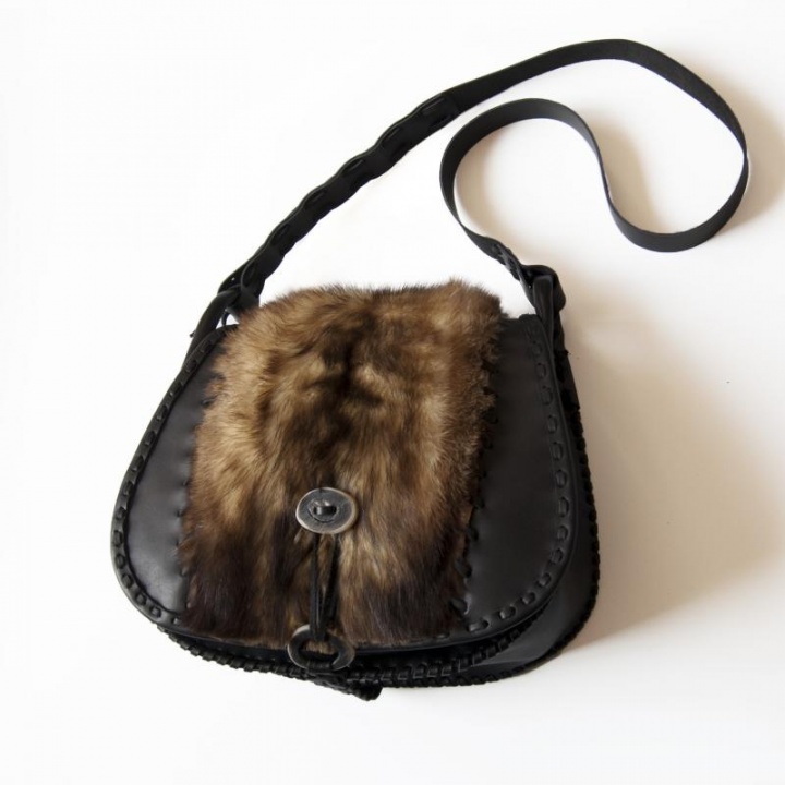 Black leather handbag decorated with fur